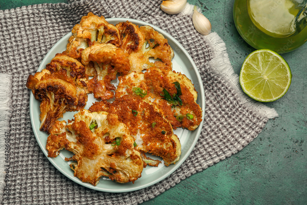 Plate with tasty fried cauliflower on color background