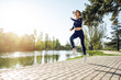 © fotofabrika - Athletic fit young woman jogging early in the morning in park
