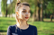 © fotofabrika - Portrait of a young smiling woman wearing sportswear in morning park