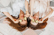 © Daria Lukoiko - Two girls make homemade face and hair beauty masks. Cucumbers for the freshness of the skin around the eyes. Women take care of youthful skin. Girlfriends laugh at home lying on the floor on pillows.