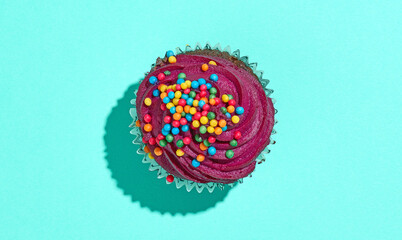 Colorful sweet cupcake on blue background top view