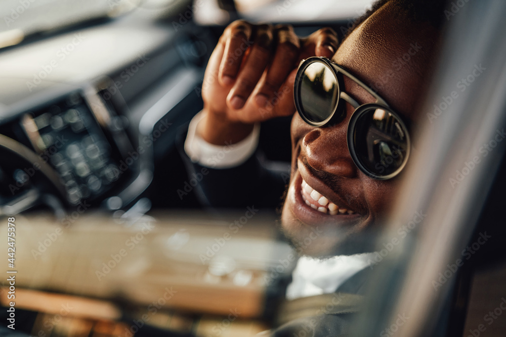 Stylish black businessman with sunglasses inside of car - obrazy, fototapety, plakaty 