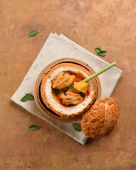 traditional peranakan nonya / malay local cook curry chicken and curry leaf with potato in round big hand made baked bread bun on wood table halal fresh sandwich menu