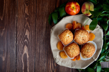 Aufkleber - top view of delicious muffins and dried apricots on a plate and fresh sweet nectarines on wooden rustic background with copy space