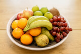 Fototapeta Kuchnia - A bowl of juicy fruits sits on a table.