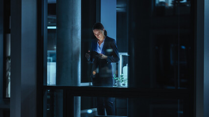 Poster - Shot from Outside: Businesswoman Working on a Tablet Computer in the Office. Manager Checking Emails while Standing by the Window. Employee Planning Financial Tasks and Business Development.