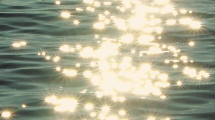 Sun rays reflecting in blue ocean water like diamonds