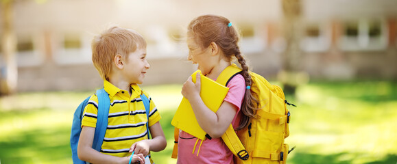 Two cute children standing in the schoolyard park