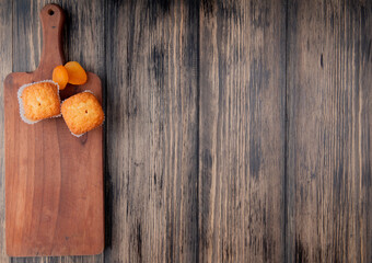 Aufkleber - top view of muffins and dried apricots on wooden cutting board on rustic background with copy space