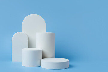 Wall Mural - white podium to show cosmetic products with geometric forms on blue background. background for brand