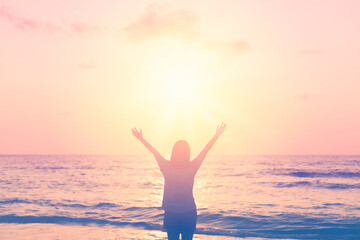 Canvas Print - Copy space of woman rise hand up on sunset sky at beach and island background.