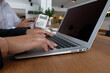 © Charlie's - Working by using a laptop computer on wooden table. Hands typing on a keyboard.technology e-commerce concept.