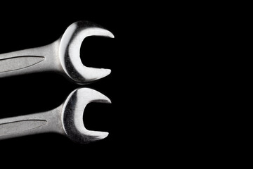 Wall Mural - Two steel wrenches isolated on black background closeup with copy space