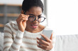 Bad Vision. Young African American Woman In Eyeglasses Looking At Smartphone Screen