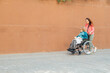 © ADDICTIVE STOCK - Woman walking with aged mother in wheelchair in street