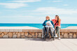 © ADDICTIVE STOCK - Daughter sitting with aged mother in wheelchair on embankment