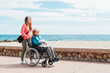 © ADDICTIVE STOCK - Daughter pushing wheelchair with aged mother on embankment