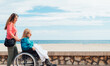 © ADDICTIVE STOCK - Daughter pushing wheelchair with aged mother on embankment