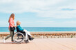 © ADDICTIVE STOCK - Daughter pushing wheelchair with aged mother on embankment