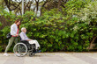 © ADDICTIVE STOCK - Daughter walking with elderly father in wheelchair in park