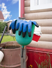 dirty rubber gloves for the garden hang on a hand washbasin against the backdrop of a country house.