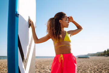 Wall Mural - Surfer woman  during summer travel beach vacation.Young woman with glanders at the beach. Extreme sport. Travel, weekend, lifestyle.