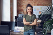 © Kostiantyn - Portrait of happy woman, interior designer or architect smiling at camera while standing with arms crossed in modern green office on a daytime