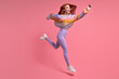 Enthusiastic redhead excited woman jump at black friday discounts wear casual style outfit clothing isolated over pink color studio background, portrait. copy space