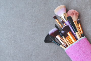 Wall Mural - Makeup brushes in bag on marble background