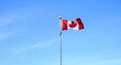 The flag of Canada on blue sky  background close up.