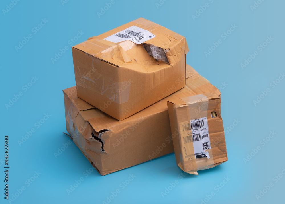 Damaged cardboard box with hole on blue background,cardboard box destroyed in shipping