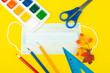 school supplies top view on a yellow background, with a place to write