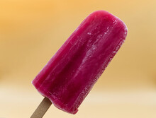 Purple Strawberry Popsicle On A Yellow Background