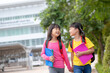 © FAMILY STOCK - Back to school. Two cute asian child girls with school bag holding book and walk together in the school