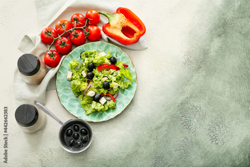 Plate with fresh Greek salad and ingredients on grunge background
