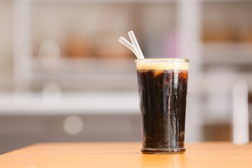 Glass of tasty iced coffee on table