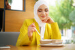 © fotofabrika - Young muslim woman in hijab having a lunch in cafe