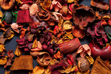  Background from dried flowers of orange and red flowers scattered on a black background.
