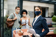 © Drazen - Female hotel receptionist wearing face mask while working during coronavirus pandemic.