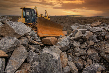 Wall Mural - Excavator in a quarry surrounded by rock to transform into gravel