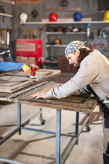 Wall Mural - Male carpenter working on old wood in a retro vintage workshop.