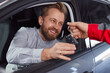 Mechanic giving car keys to happy customer in repair service salon
