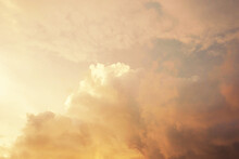 Beautiful Fluffy Clouds Color White, Yellow And Peach. A Cloudscape At Golden Hour. Background For Natural Design.