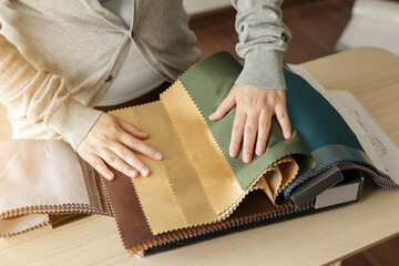 female designer with fabric color samples choosing textile for curtains