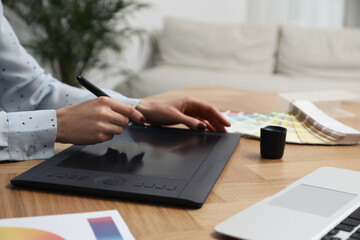 Poster - Professional designer with graphic tablet at wooden table, closeup