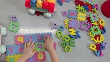 Top View Of A Toddler Boy Playing Alphabet Puzzle To Learning English