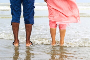 Exotic get way. Young couple walking on a beautiful white sand beach. Couple lovers standing on the sandy beach together, romantic honeymoon trip.