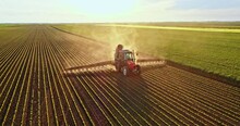 Farmer On Tractor Spraying Soybean Field