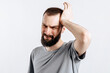 © Daria Lukoiko - Portrait of handsome young man frowning while holding hands near head on white background with space for advertising mock up