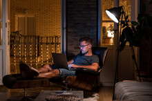 Male Freelancer Working In Evening At Home